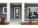 Inviting front entrance features a gray door, white pillars, and outdoor seating for relaxing at 72 Fairway Cir, Umatilla, FL 32784