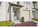 Inviting front entrance with a light blue door, complemented by colorful landscaping at 734 Longboat Dr, Davenport, FL 33896