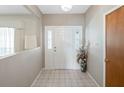 Bright entryway with decorative tiled floor, large white door, and beautiful transom windows at 7540 Lake Marsha Dr, Orlando, FL 32819