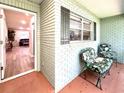 Inviting front porch with brick detail, flanked by chairs and overlooking a glimpse of the home's living area at 9490 Sw 85Th Ave # E, Ocala, FL 34481