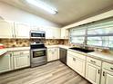 Bright kitchen featuring modern stainless steel appliances, light countertops, and stylish backsplash at 9490 Sw 85Th Ave # E, Ocala, FL 34481