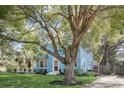 Attractive blue two-story home featuring a well-maintained lawn and a mature tree adding character at 1000 Pennsylvania Ave, Lakeland, FL 33803