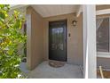 Inviting front entry featuring a black screen door, exterior lighting, and lush flowering bushes at 130 Kristi Ann Ct, Winter Springs, FL 32708