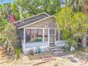 Charming home with mature landscaping, pink flowers and a screened porch at 1314 S Mellonville Ave, Sanford, FL 32771