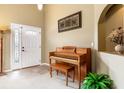 Inviting entryway with a tiled floor, a decorative niche, a piano, and a brightly lit front door at 1457 Waukon Cir, Casselberry, FL 32707