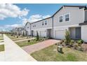 Row of modern townhomes with manicured landscaping, brick driveways, and ample parking in a desirable neighborhood at 16391 Bird Of Paradise Ave, Clermont, FL 34714