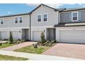 Inviting townhomes featuring brick driveways, attached garages, and fresh landscaping for a welcoming curb appeal at 16391 Bird Of Paradise Ave, Clermont, FL 34714