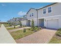Wide angle exterior view of the neighborhood townhomes with brick driveways at 16399 Bird Of Paradise Ave, Clermont, FL 34714