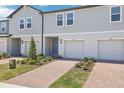 Close-up view of townhomes with brick driveways and well-manicured landscaping at 16399 Bird Of Paradise Ave, Clermont, FL 34714