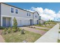 Exterior view of townhomes with brick driveways, landscaping, and light-colored exteriors at 16399 Bird Of Paradise Ave, Clermont, FL 34714