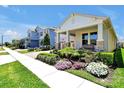 Inviting single-Gathering home showcases a landscaped front yard with flowering shrubs, a cozy porch with a bench, and a two-car garage at 16527 Sea Glass St, Winter Garden, FL 34787