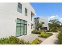 A modern home boasts large windows and doors surrounded by lush green landscaping at 1768 Mondrian Cir, Winter Park, FL 32789
