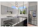 Modern kitchen featuring gray cabinets, sleek countertops, and stainless steel appliances at 1768 Mondrian Cir, Winter Park, FL 32789