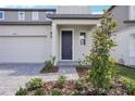 Inviting front entrance with a blue door, paved walkway, and beautiful landscaping at 1801 Archer Dr, Minneola, FL 34715
