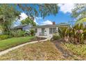 Charming home featuring a curved walkway to the front door, mature landscaping, and a brick facade at 1845 Delaney Ave, Orlando, FL 32806