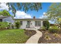 Charming home featuring a curved walkway to the front door, mature landscaping, and a brick facade at 1845 Delaney Ave, Orlando, FL 32806