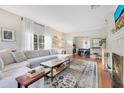 Bright living room features hardwood floors, a large sectional, and an open layout to the dining area at 1845 Delaney Ave, Orlando, FL 32806