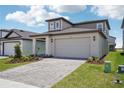 Lovely home with a two-car garage and paved driveway, enhanced by lush landscaping and exterior lighting at 1904 Archer Dr, Minneola, FL 34715