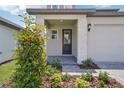 Inviting front porch with stone accents, a stylish front door, and manicured landscaping at 1904 Archer Dr, Minneola, FL 34715