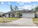 Single-story home featuring manicured landscaping and an attached two-car garage at 2028 Sussex Rd, Winter Park, FL 32792