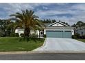 Inviting home featuring a lush green lawn and a spacious driveway at 24125 Peekskill St, Leesburg, FL 34748