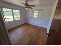 Empty bedroom with hardwood floors, a ceiling fan, and multiple windows for natural light at 2523 Falkner Rd, Orlando, FL 32810
