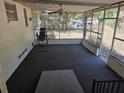 Enclosed screened porch with dark carpeting, ceiling fan, and a view of the backyard at 2523 Falkner Rd, Orlando, FL 32810