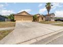 Front exterior of a one story home with a large driveway and mature palm trees in a friendly neighborhood at 2739 Village Pine Ter, Orlando, FL 32833