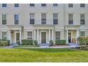 Inviting townhouse facade with lush landscaping, a covered entryway, and classic design at 312 Grand Bay Ln, Celebration, FL 34747