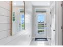 Bright entryway featuring a modern door with glass panels, light tile floors, and shiplap accent wall at 3206 Partington Blvd, Davenport, FL 33837