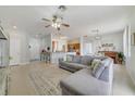 Inviting living area features an open floor plan with tile flooring, a ceiling fan, and a breakfast bar at 4544 Point Look Out Rd, Orlando, FL 32808