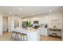 Bright kitchen featuring an island with seating, stainless steel appliances, and white cabinetry at 4718 Yellow Elder Way, Kissimmee, FL 34758