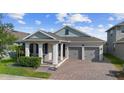 Attractive single-story home featuring a brick driveway, a covered porch, and an attached two-car garage at 5511 Orange Orchard Dr, Winter Garden, FL 34787