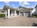 Inviting single-story home with a brick driveway, a covered porch, and an attached garage at 5511 Orange Orchard Dr, Winter Garden, FL 34787