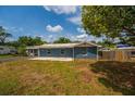 Single-story home with blue siding and a concrete patio, surrounded by well-kept grass and mature trees at 55119 5Th St, Astor, FL 32102
