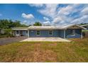 Single-story home with blue siding and a concrete patio, set on a well-maintained grassy lot at 55119 5Th St, Astor, FL 32102