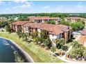 Apartment building exterior view showcasing multiple units with private balconies overlooking a pond and grassy area at 5530 Metrowest Blvd # 309, Orlando, FL 32811
