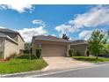 Spacious two-car garage with a neutral color scheme and well-kept lawn, nestled in a quiet neighborhood at 6822 Habitat Dr, Harmony, FL 34773