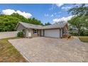 Charming home with brick accents, a two-car garage, and a beautifully paved driveway at 694 Tuscora Dr, Winter Springs, FL 32708
