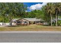 Charming single-story home featuring a well-manicured lawn and beautiful mature trees at 694 Tuscora Dr, Winter Springs, FL 32708