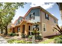 Exterior view of a well-maintained townhome with red tile roof, colorful siding, and landscaped surroundings at 7348 Yoder St, Windermere, FL 34786