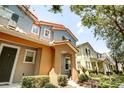 Eye-level view of a townhome featuring colorful architecture, well-kept landscaping, and inviting entryway at 7348 Yoder St, Windermere, FL 34786