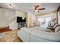 Open-concept living room with tile flooring, neutral paint, ceiling fan and view into the dining and kitchen areas at 7348 Yoder St, Windermere, FL 34786