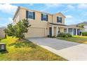 Attractive two-story home with blue shutters, a two-car garage, and a driveway surrounded by green grass at 740 Simone Ct, Haines City, FL 33844
