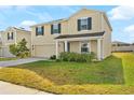 Lovely two-story home with blue shutters, a two-car garage, and manicured front lawn and lush landscaping at 740 Simone Ct, Haines City, FL 33844