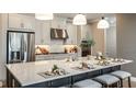Modern kitchen featuring stainless steel appliances, a large island with seating, and stylish pendant lighting at 857 Junonia Blvd, New Smyrna Beach, FL 32168