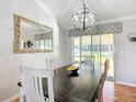Bright dining room with modern chandelier, a dark wood table, and sliding glass doors to a screened patio at 1072 Se 155Th St, Summerfield, FL 34491