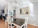 Inviting dining room with modern chandelier, a dark wood table, and views of a stone fireplace at 1072 Se 155Th St, Summerfield, FL 34491