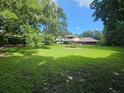 Spacious backyard with lush green lawn, mature trees, and a patio area at 11056 Clipper Ct, Windermere, FL 34786