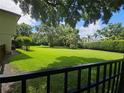 Large, well-maintained backyard with a lush green lawn and mature trees, viewed from behind a wrought iron fence at 11056 Clipper Ct, Windermere, FL 34786
